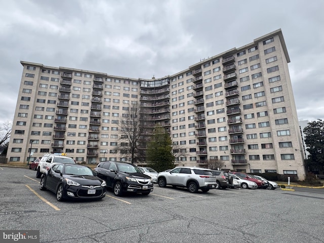 view of building exterior with uncovered parking