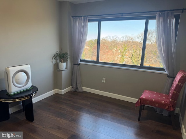 living area with baseboards and dark wood finished floors