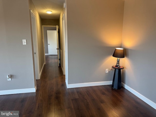 hall featuring dark wood finished floors and baseboards