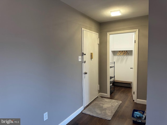 corridor with baseboards and dark wood-type flooring