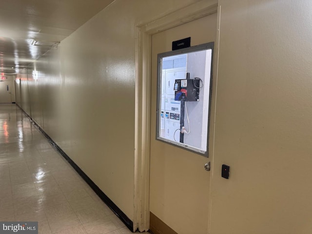 corridor featuring light floors and baseboards