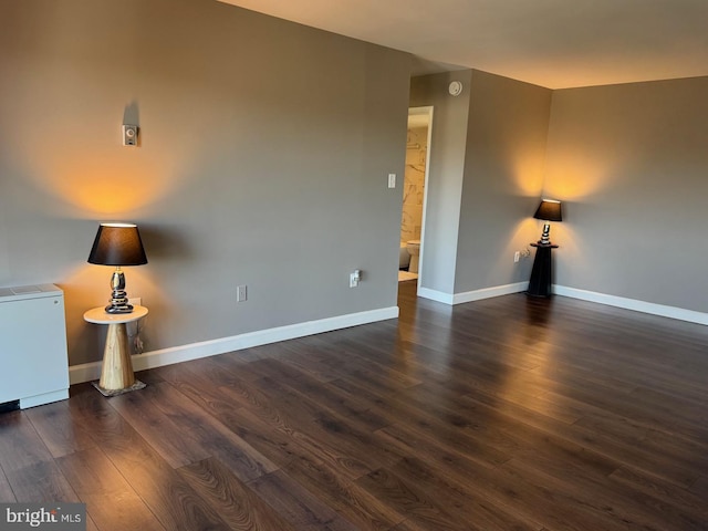 spare room featuring wood finished floors and baseboards