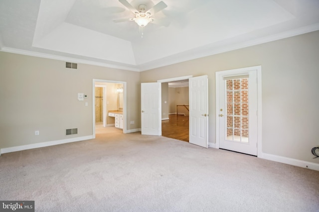 unfurnished bedroom with visible vents, a raised ceiling, baseboards, and carpet flooring