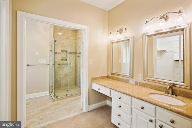 bathroom with a shower stall, vanity, and baseboards