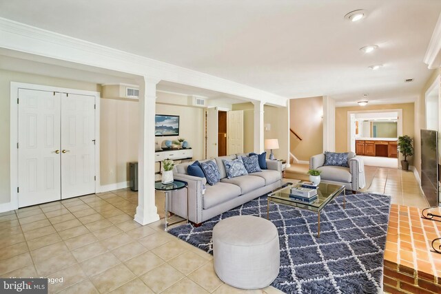 living room featuring tile patterned flooring, stairway, visible vents, and ornamental molding