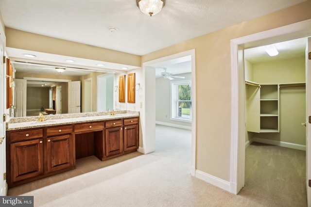 full bath featuring carpet, baseboards, double vanity, ceiling fan, and a sink