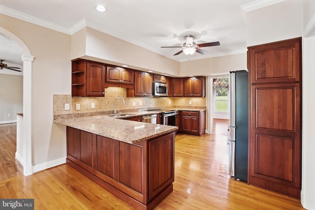 kitchen featuring a ceiling fan, a peninsula, open shelves, a sink, and stainless steel appliances