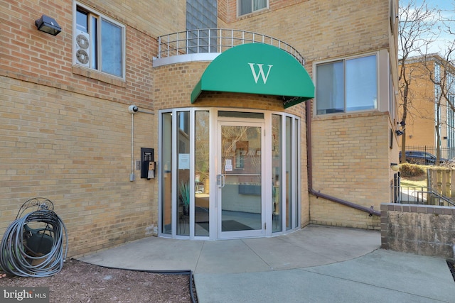 property entrance featuring brick siding and a patio area