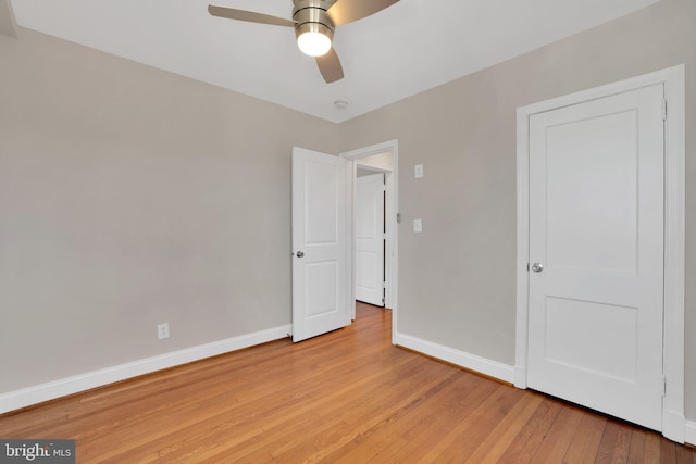 unfurnished bedroom featuring ceiling fan, light wood-style flooring, and baseboards