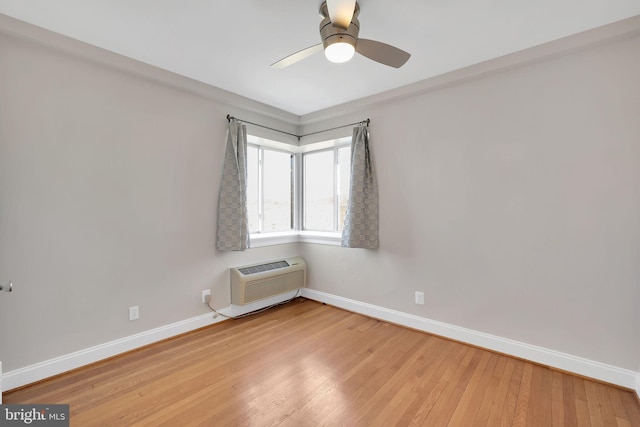 unfurnished room with light wood finished floors, ceiling fan, baseboards, and a wall mounted AC