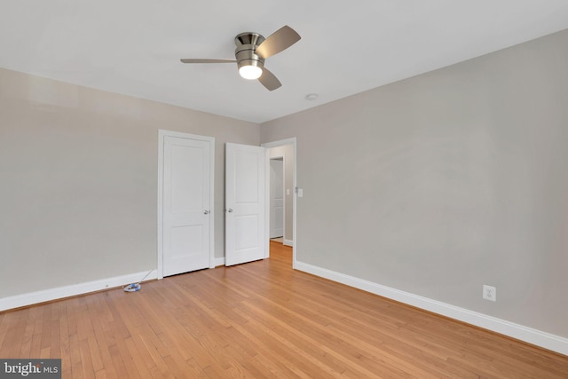 unfurnished bedroom with light wood-style floors, ceiling fan, and baseboards