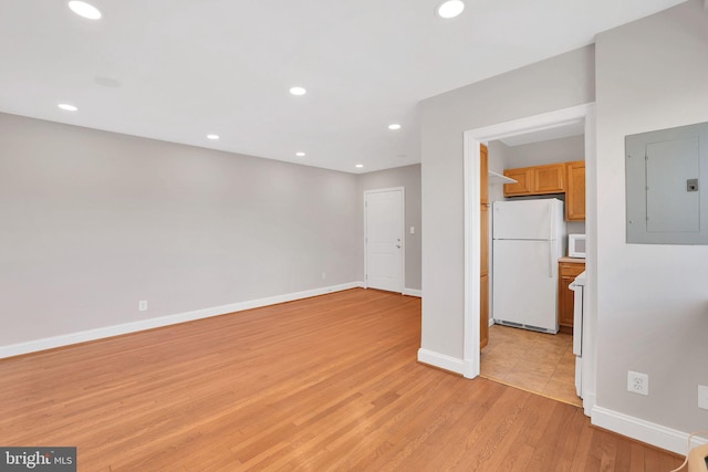 interior space featuring light wood-type flooring, electric panel, baseboards, and recessed lighting