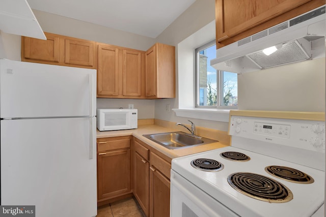 kitchen with white appliances, light countertops, under cabinet range hood, a sink, and light tile patterned flooring