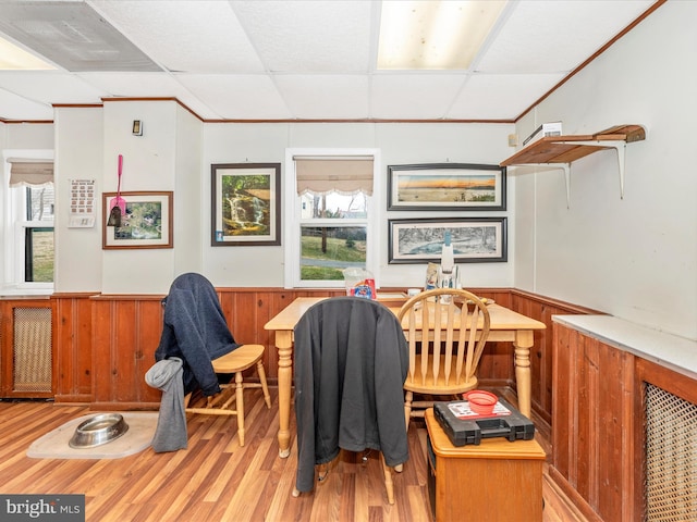 home office featuring a wainscoted wall, wood walls, a paneled ceiling, and light wood-style floors