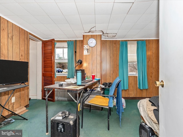 home office with carpet, wooden walls, and crown molding