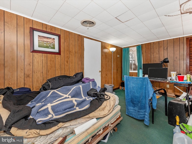 bedroom featuring carpet flooring, visible vents, and wood walls