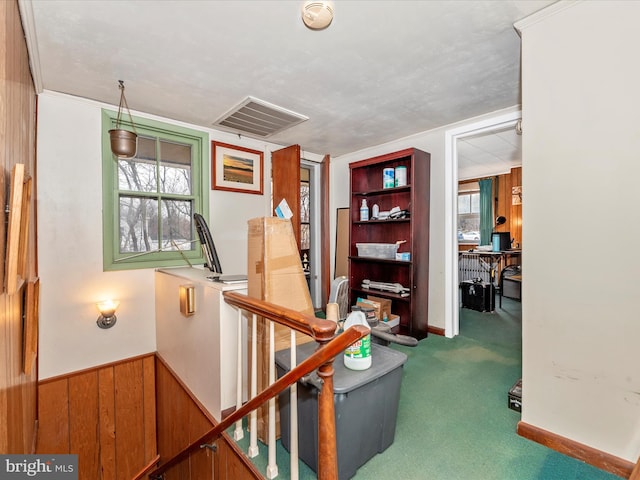 interior space with visible vents, carpet floors, wood walls, and wainscoting