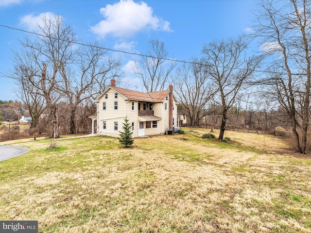 view of side of property with a yard and a chimney