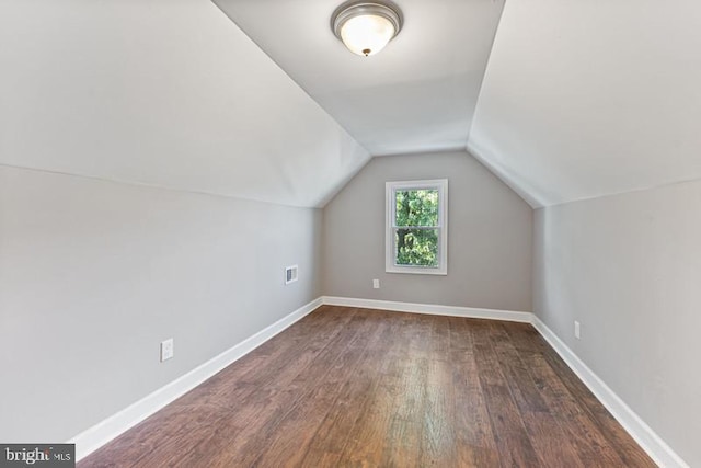 bonus room with lofted ceiling, dark wood finished floors, visible vents, and baseboards