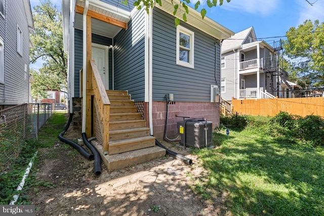 rear view of house with central AC and fence