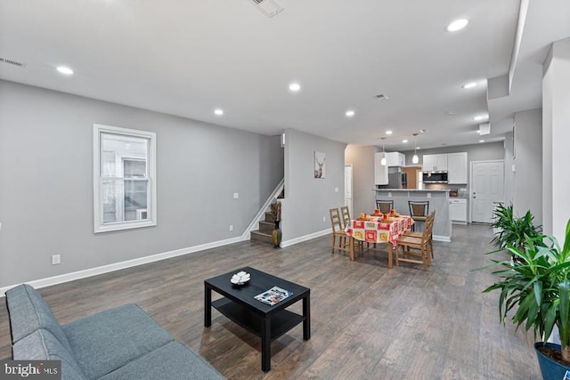 living area featuring baseboards, stairway, dark wood-style flooring, and recessed lighting