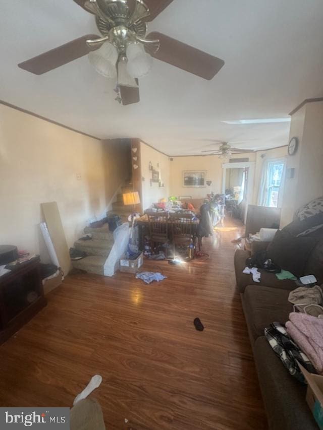 living room featuring ceiling fan, stairway, and wood finished floors