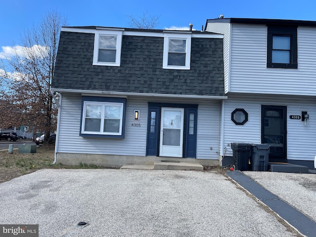 multi unit property featuring mansard roof and roof with shingles