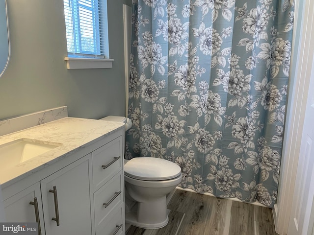 full bath with vanity, a shower with curtain, toilet, and wood finished floors