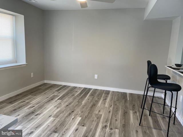 dining room with ceiling fan, baseboards, and wood finished floors