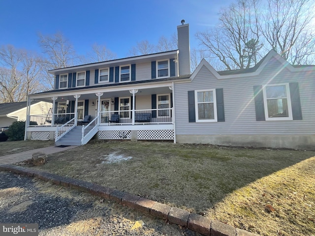 view of front of property with a chimney, covered porch, and a front yard