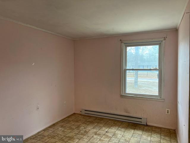 spare room with a baseboard heating unit, crown molding, light floors, and baseboards