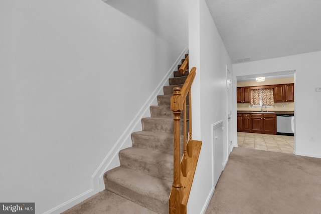 stairs featuring visible vents, baseboards, and carpet floors