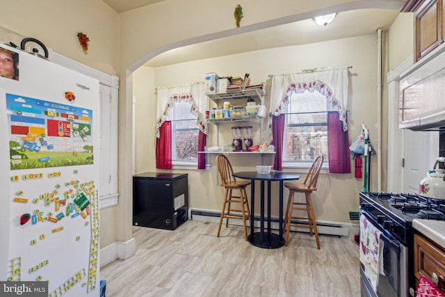 kitchen featuring white appliances, baseboards, arched walkways, brown cabinets, and baseboard heating