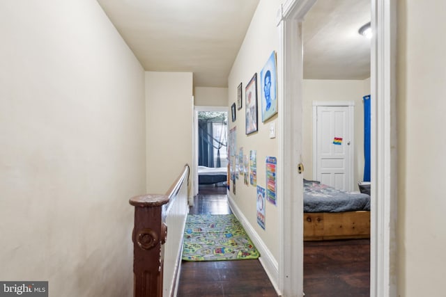 hallway featuring baseboards and dark wood-style flooring