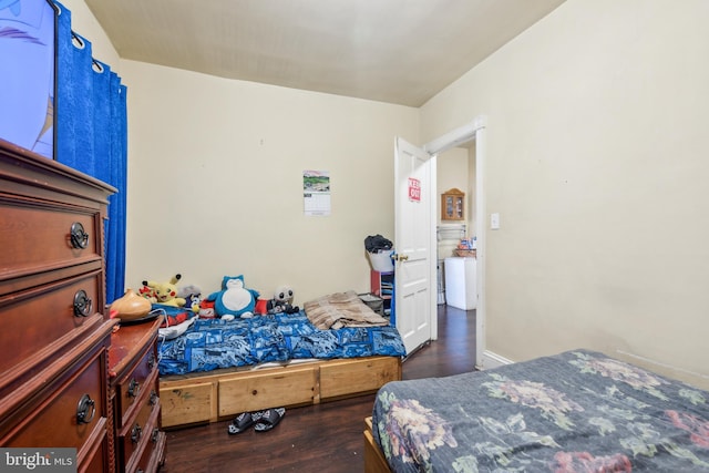 bedroom with washer / clothes dryer and wood finished floors