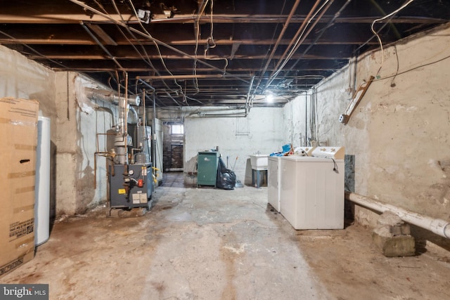 unfinished below grade area featuring a heating unit and washer and clothes dryer