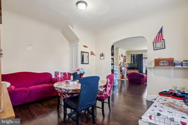 dining room featuring arched walkways and wood finished floors