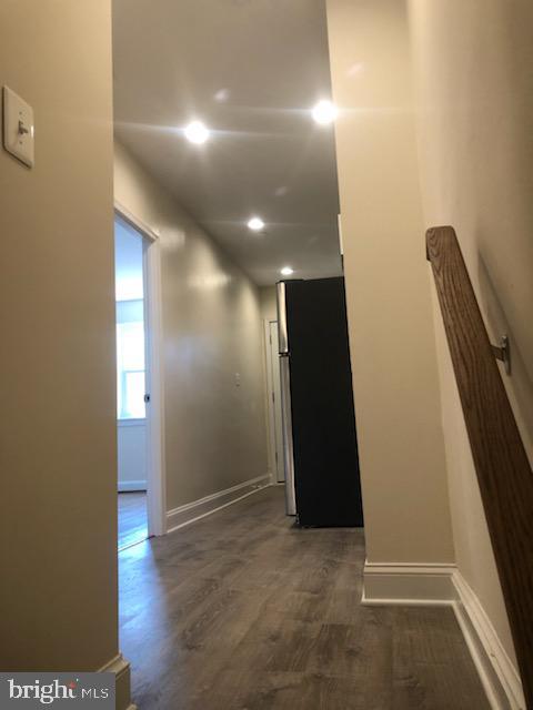 hallway with dark wood finished floors and baseboards