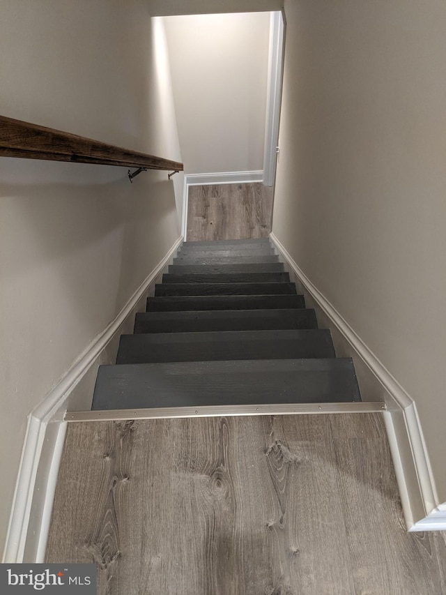 stairs featuring baseboards and wood finished floors