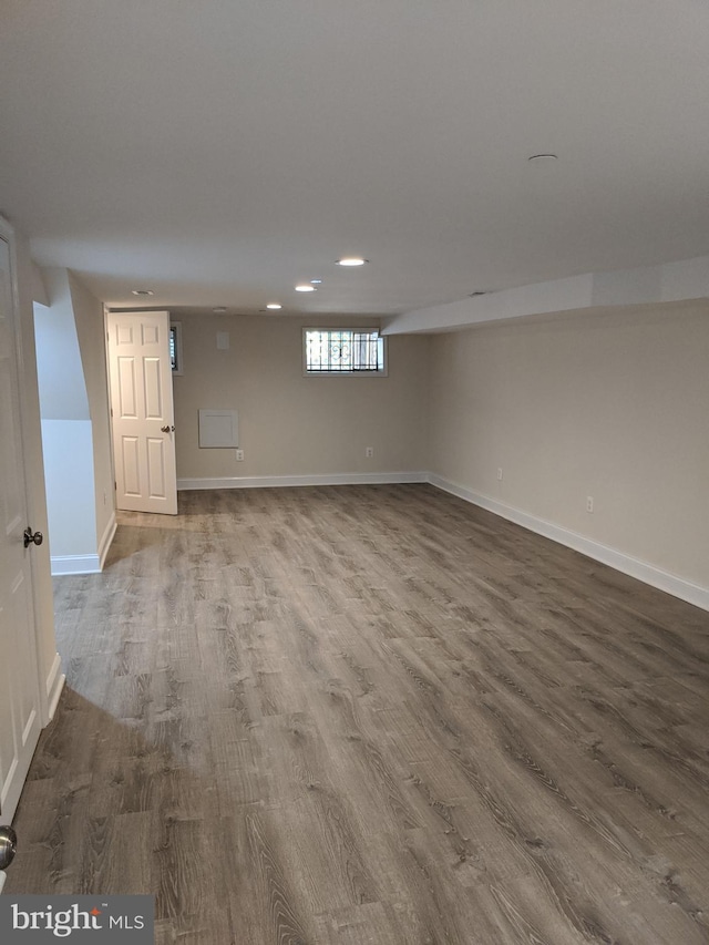 below grade area featuring recessed lighting, wood finished floors, and baseboards