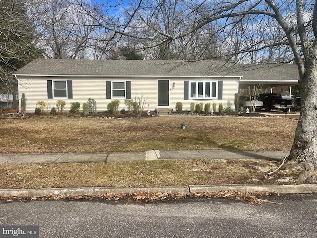 single story home featuring an attached carport, roof with shingles, and entry steps