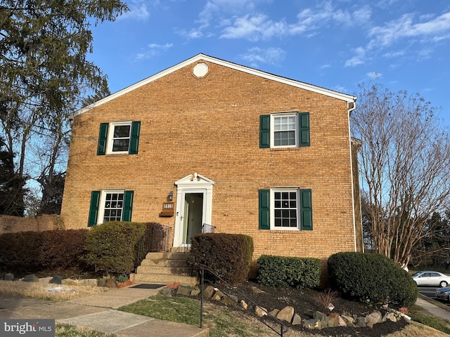 colonial inspired home with brick siding