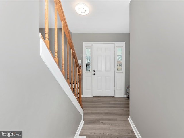 entrance foyer with stairway, baseboards, and wood finished floors