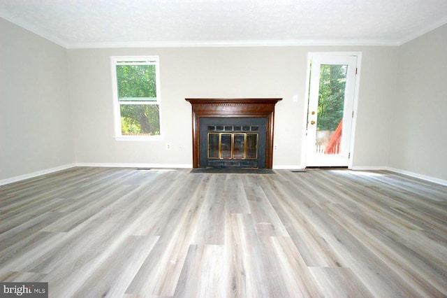 unfurnished living room featuring a fireplace with flush hearth, baseboards, and wood finished floors