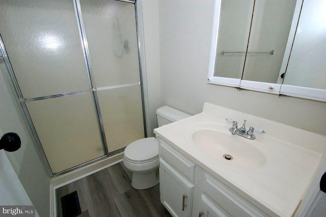 full bath with vanity, a shower stall, toilet, and wood finished floors