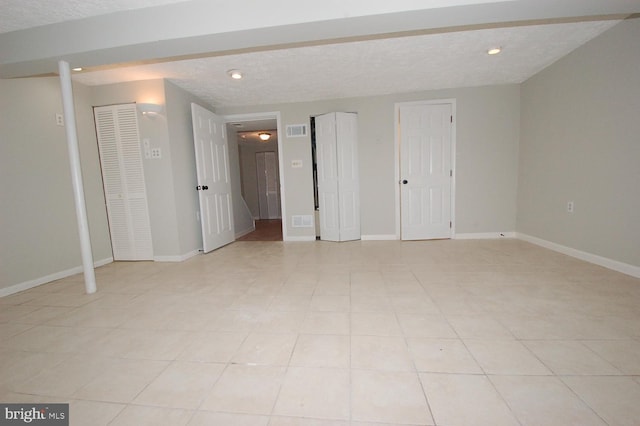 interior space with visible vents, recessed lighting, a textured ceiling, and baseboards