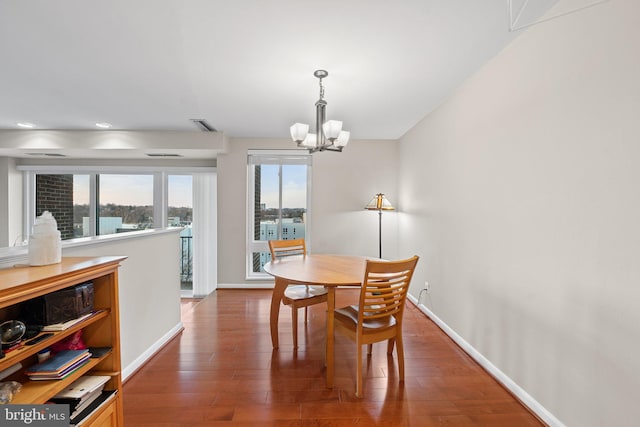 dining area featuring baseboards, an inviting chandelier, and wood finished floors