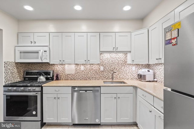 kitchen with recessed lighting, backsplash, stainless steel appliances, and a sink