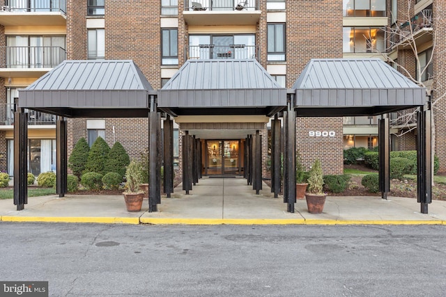 exterior space featuring a standing seam roof, brick siding, and metal roof