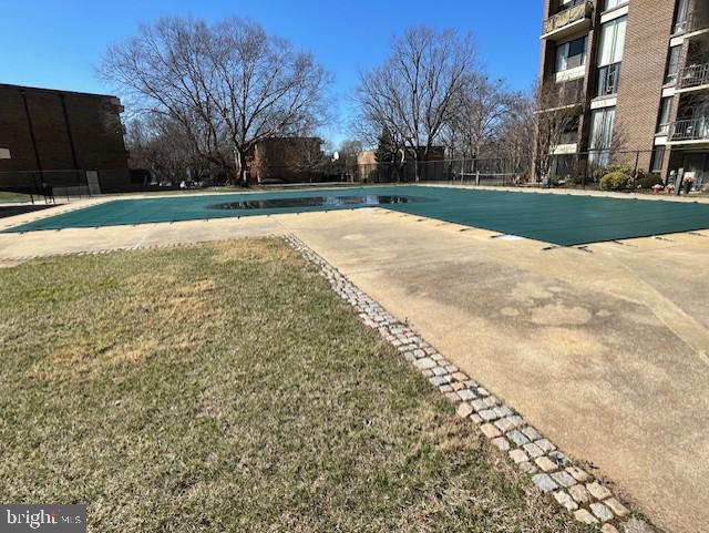 community pool with a yard and fence